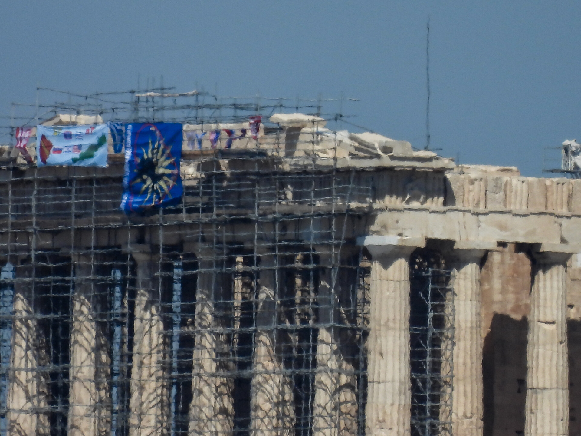 Άνδρας σκαρφάλωσε από σκαλωσιά στον Παρθενώνα και κρέμασε σημαίες © Eurokinissi