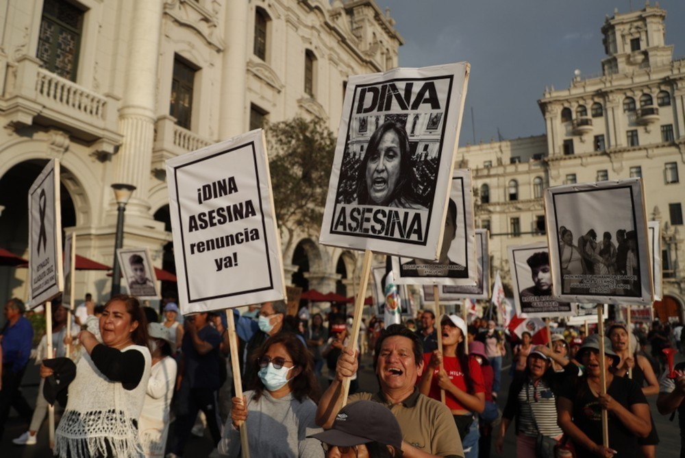 Διαδηλωτές κρατούν φωτογραφίες της προέδρου Ντίνα Μπολουάρτε, στις οποίες χαρακτηρίζεται ως δολοφόνος κατά τη διάρκεια κινητοποίησης στη Λίμα του Περού. @EPA/Paolo Aguilar