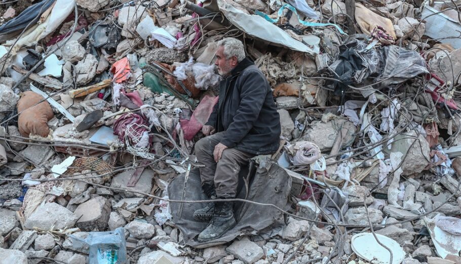 Ένας άνδρας κάθεται πάνω σε συντρίμμια περιμένοντας νέα από την οικογένειά του στο σημείο όπου κατέρρευσαν κτίρια μετά από ισχυρό σεισμό, στο Χατάι της Τουρκίας @ EPA/SEDAT SUNA