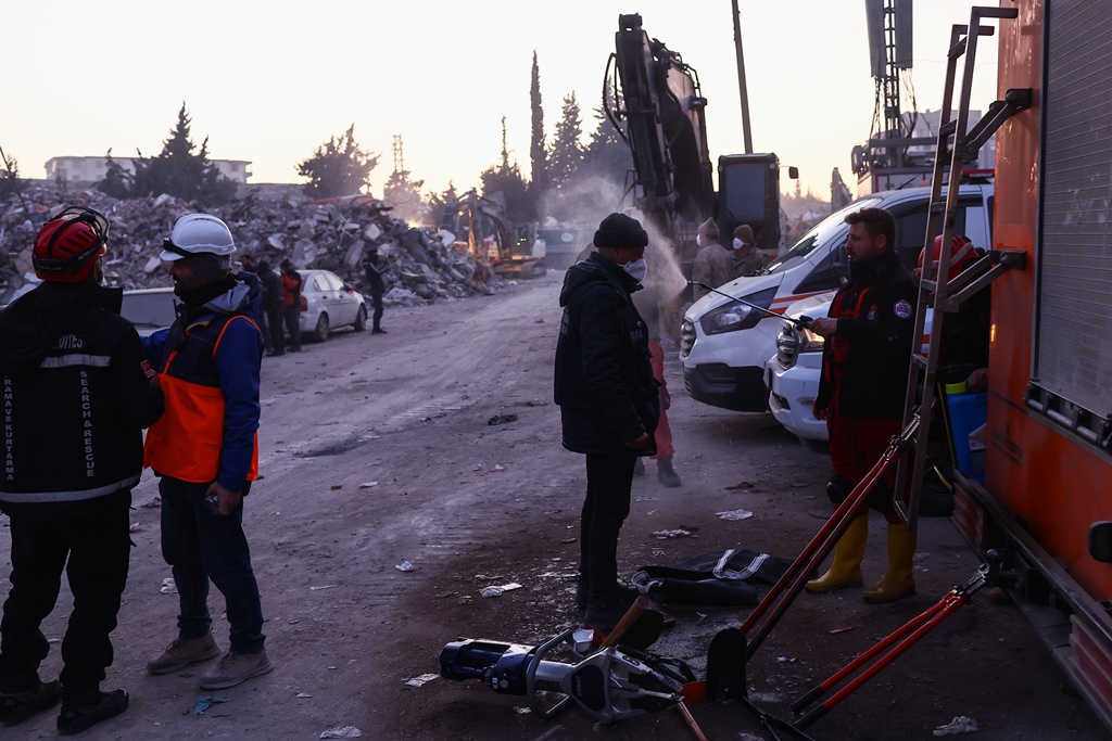 Εργάτες απολυμαίνουν κοντά σε κτίρια που κατέρρευσαν στο Χατάι της Τουρκίας μετά από το σεισμό @ EPA/SEDAT SUNA