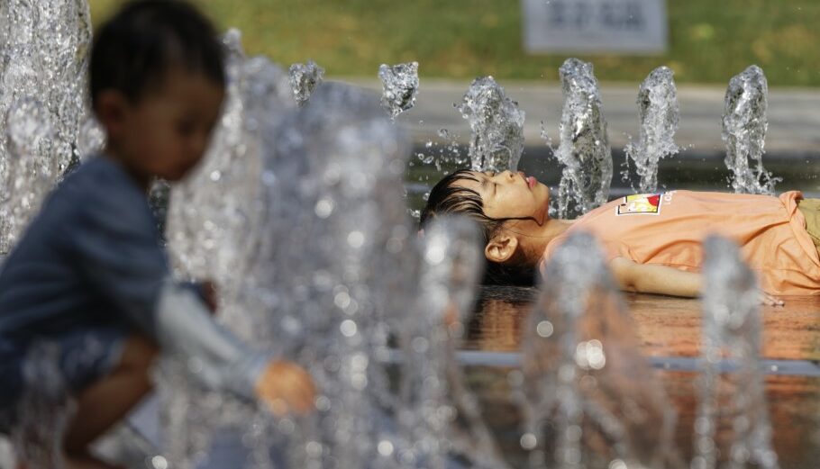Παιδιά στη Σαγκάη παίζουν με το νερό σε συντριβάνι © EPA/ALEX PLAVEVSKI