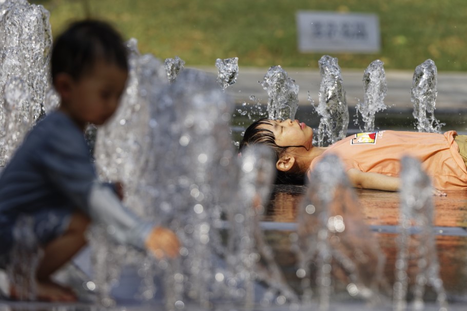 Παιδιά στη Σαγκάη παίζουν με το νερό σε συντριβάνι © EPA/ALEX PLAVEVSKI