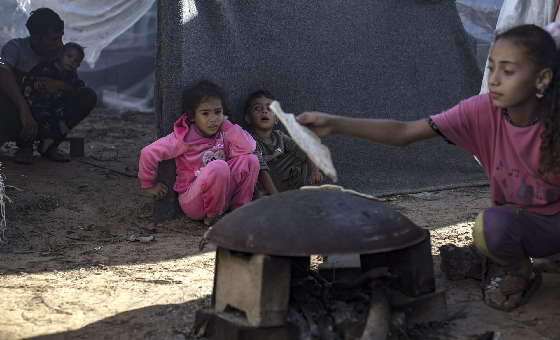 Παιδιά στη Γάζα περιμένουν να ψηθεί το ψωμί σε καταυλισμό © EPA/HAITHAM IMAD