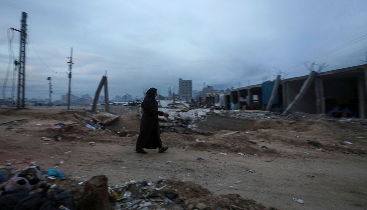 Παλαιστίνια περπατά στα ερείπια κατεστραμμένων κτιρίων στη Λωρίδα της Γάζας © EPA/MOHAMMED SABER