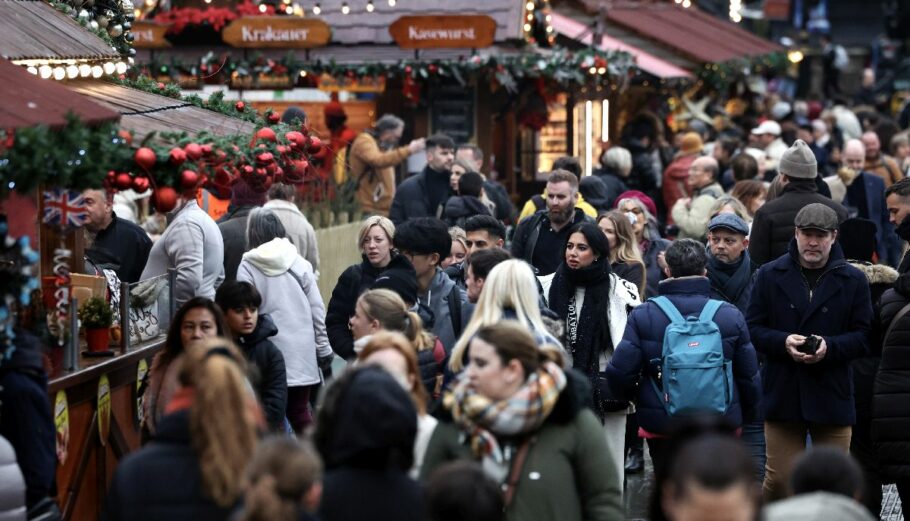 Άνθρωποι περπατούν σε χριστουγεννιάτικη αγορά στο Λονδίνο, Βρετανία © EPA/ANDY RAIN
