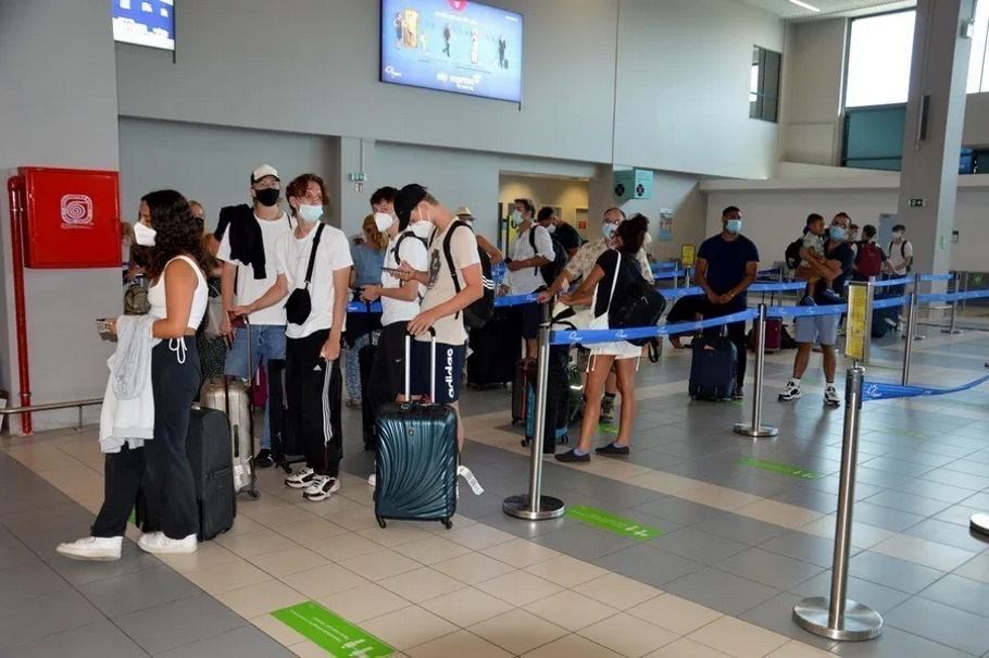 Τουρίστες περιμένουν στην ουρά του ελέγχου εισιτηρίων, ώστε να επιβιβαστούν σε πτήση@ΑΠΕ-ΜΠΕ